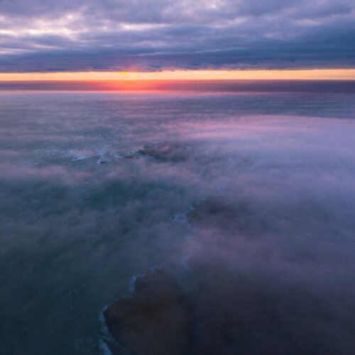 Drone flight above a layer of sea mist over the island of Anglesey Anglesey, Wales