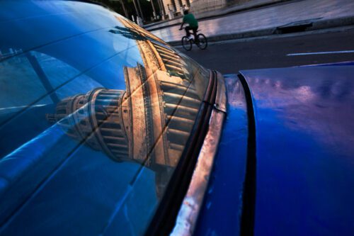 Reflection of El Capitolio in a vintage car window reflection; El Capitolio; Cuba; car; vintage; window; bicycle; street; bike; blue