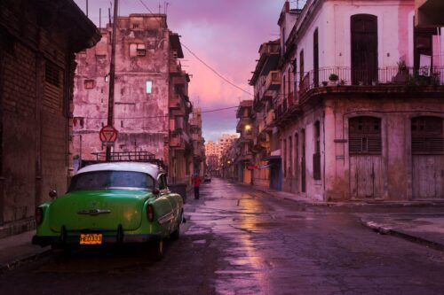 Pink colours of sunrise in old Havana Havana; sunrise; Cuba; street; Chevy; vintage car; people; buildings; old; facades; dawn; travel