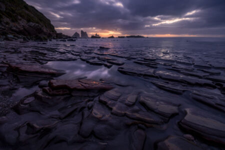The intriguing and colourful rock formations on the west coast reflecting a beautiful sunset Motukiekie, west coast, Greymouth, New Zealand