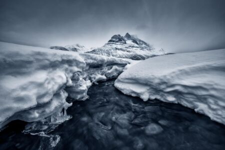 A creek running through an icy landscape in northern Norway Norway