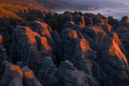 Pancake rocks of Punakaiki glowing blood red at sunset Punakaiki, pancake rocks, New Zealand